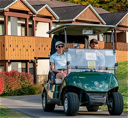 Two people in golf cart leaving the inn for a round of golf
