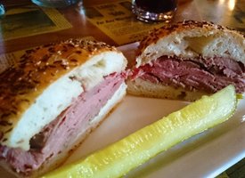 Platter of corned beef sandwich and pickle