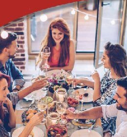 5 people at a table enjoying dinner and drinks